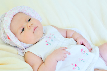 adorable baby girl wearing white dressの写真素材