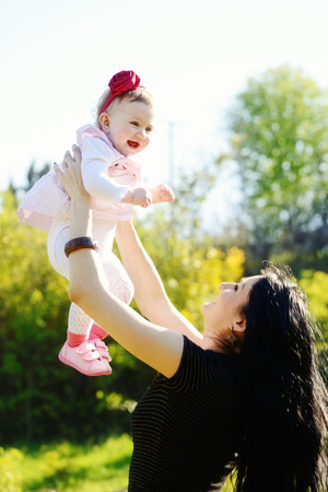 young mother having fun with baby daughter (focus on baby)の写真素材