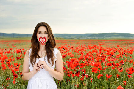 girl with heart in poppy fieldの写真素材