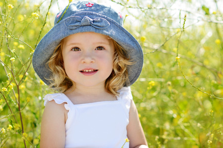 happy toddler girl in rape fieldの写真素材