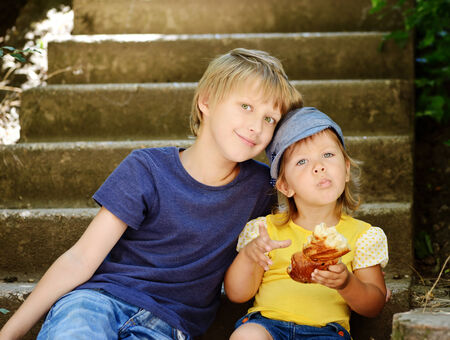 brother and sister sitting on the stairsの写真素材