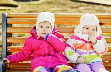  toddler friends sitting on the benchの写真素材