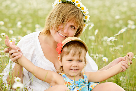 fun of little girl  and her mother in daisy fieldの写真素材