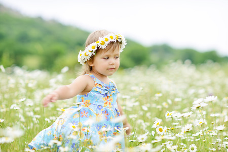 dancing toddler girl in  daisy fieldの写真素材