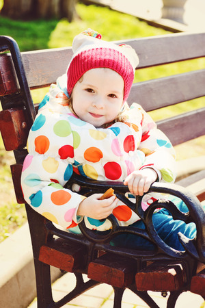 toddler girl sitting on the benchの写真素材