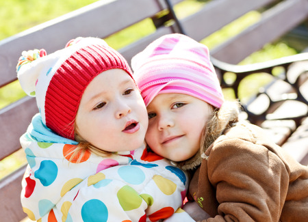 two toddler friends hugging outdoorsの写真素材