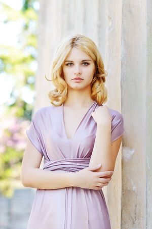 lovely beautiful girl standing near the columnの写真素材