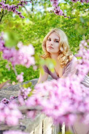 Happy young woman in spring flowers gardenの写真素材