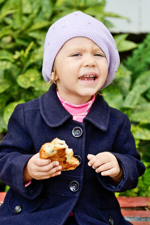 funny toddler girl eating outdoorsの写真素材