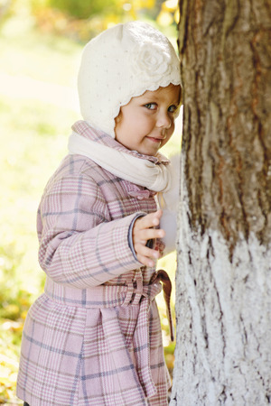 shy toddler girl near the treeの写真素材
