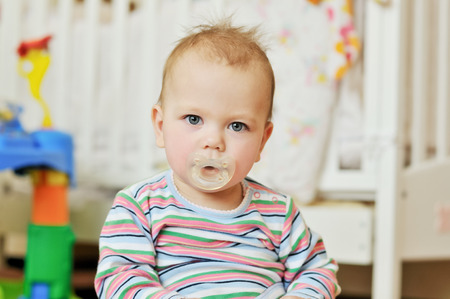   portrait of  baby with dummy at homeの写真素材