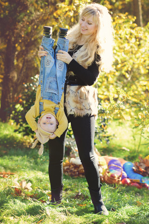 fun of mother and baby son in fallの写真素材