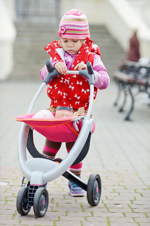 cute baby on the walk with toy strollerの写真素材