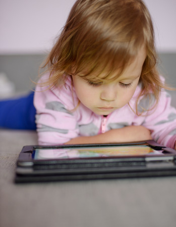 Cute toddler girl using tablet pcの写真素材