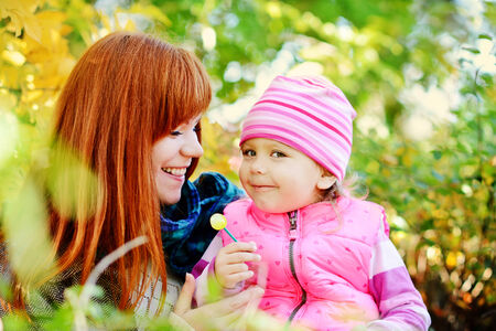 teen sister and baby sister having fun outdoors in fall timeの写真素材