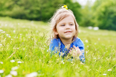 toddler girl relaxing on the meadowの写真素材