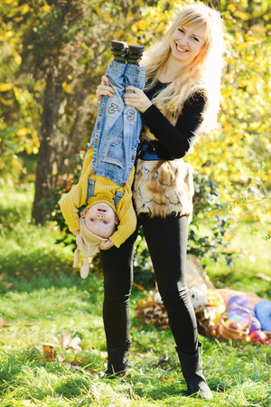 fun of mother and baby son in fallの写真素材