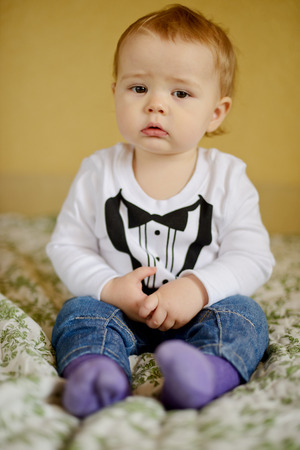 cute baby boy sitting on the sofa の写真素材