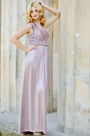 beautiful lady wearing long dress near the columnsの写真素材