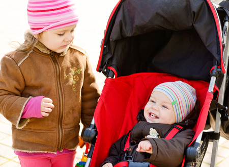 baby boy and toddler girl on the walkの写真素材