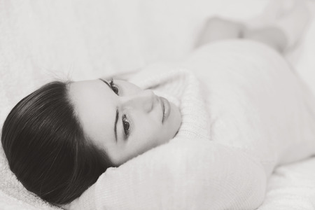 pretty pregnant woman laying on the sofa in black and whiteの写真素材