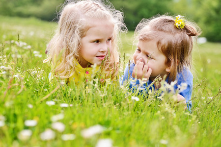 two friends girls lying on the meadowの写真素材