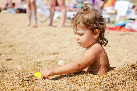 toddler girl playing on the beachの写真素材