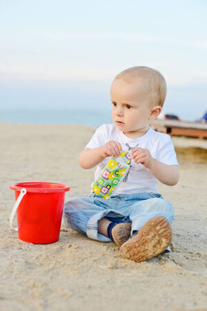 boy on the beach playing with sandの写真素材