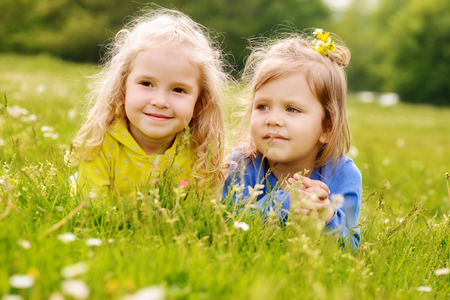 two friends girls lying on the meadowの写真素材