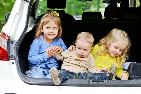 funny children sitting in the carの写真素材