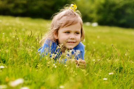  cute toddler girl lying on the meadowの写真素材