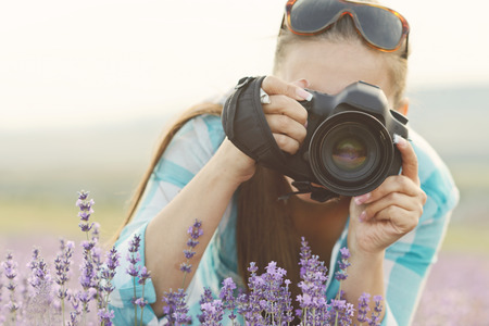 woman with camera in the fieldの写真素材