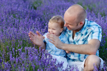 father and son playing pat-a-cake in the fieldの写真素材