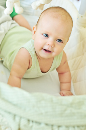 happy baby lying in cribの写真素材