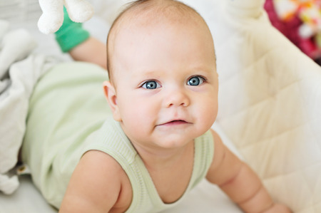 happy baby lying in cribの写真素材