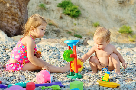 children on the beach playing toysの写真素材