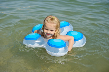child in ring swimming in seaの写真素材