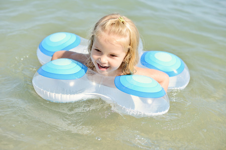child in ring swimming in seaの写真素材