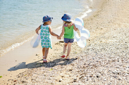 two friends with rings walking hand in hand on the summer beachの写真素材