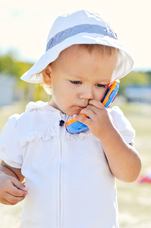 busy baby girl walking with toy phoneの写真素材