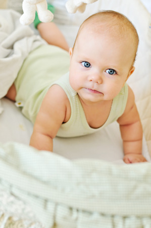 happy baby lying in cribの写真素材