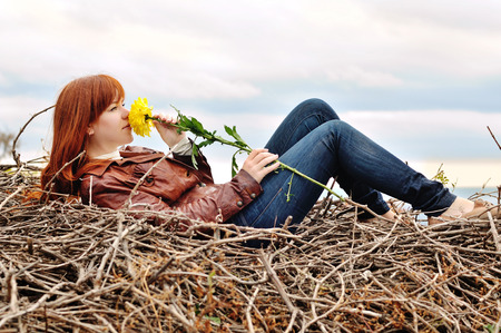 redhead girl with autumn flowerの写真素材