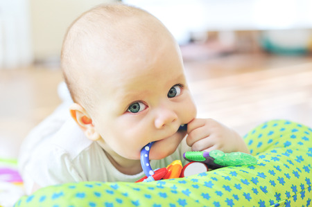baby with toy in mouthの写真素材