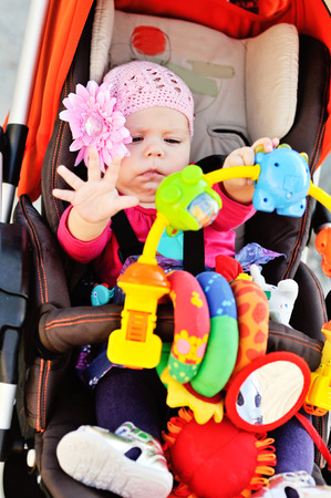 baby in stroller playing toysの写真素材