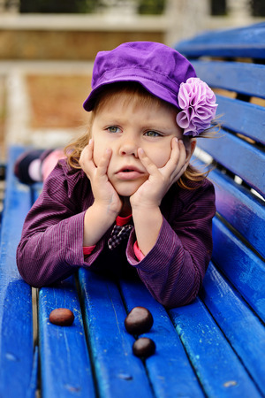 cute toddler on the bench with chestnutsの写真素材