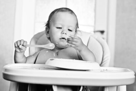 ditry eating baby with spoonの写真素材