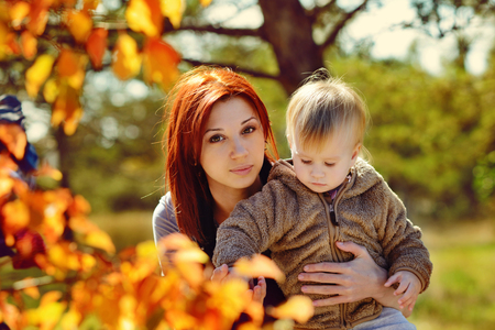 Young mother and her little girl in autumnの写真素材
