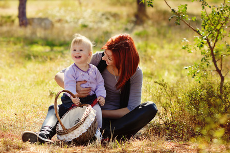 Young mother and her little girl in autumn - focus on mother faceの写真素材