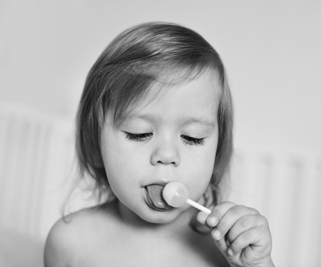 toddler girl with sweet lollipopの写真素材