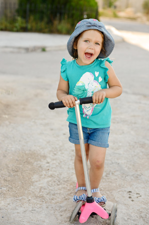 toddler girl on the scooter outdoorsの写真素材
